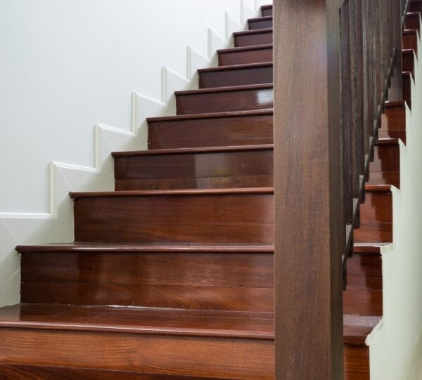 A 20-steps polished wooden stairs with smooth wooden rails on the left corner of the dining room, leading to second storey